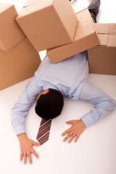 Man in suit lying under boxes